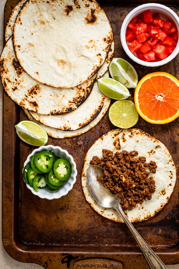 ground venison tacos on a sheet pan with all of the toppings out