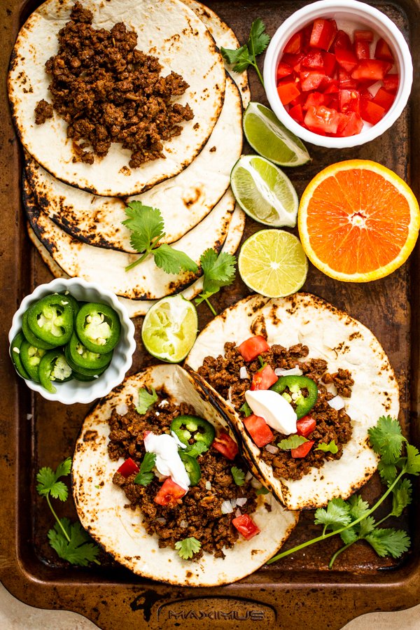 ground venison tacos on a sheet pan with all of the toppings out