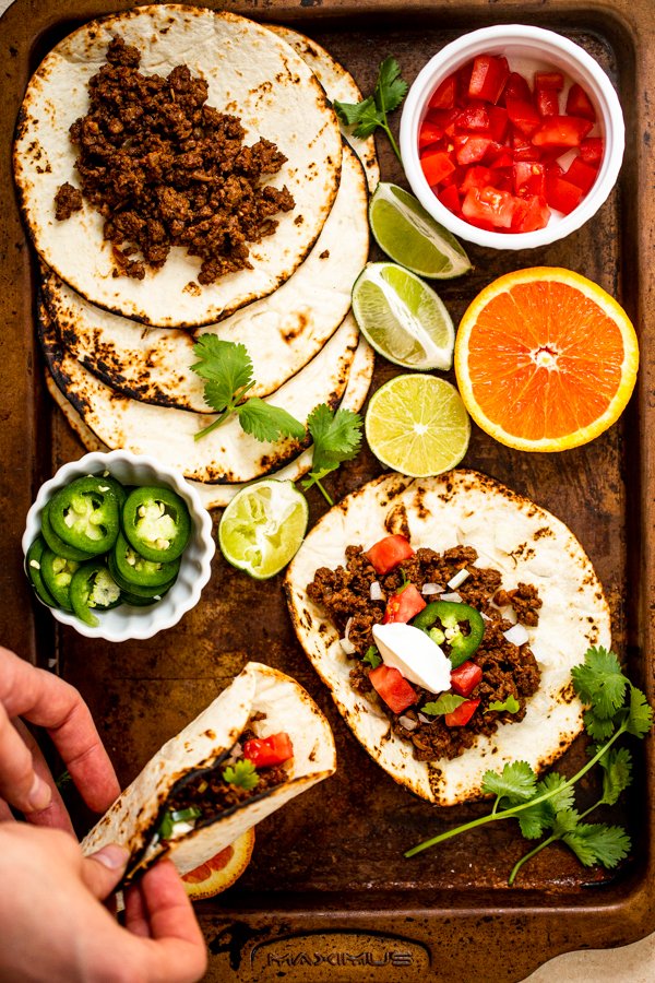 ground venison tacos on a sheet pan with all of the toppings out