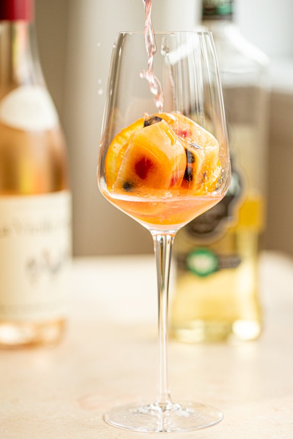 wine glass filled with berry ice cubes