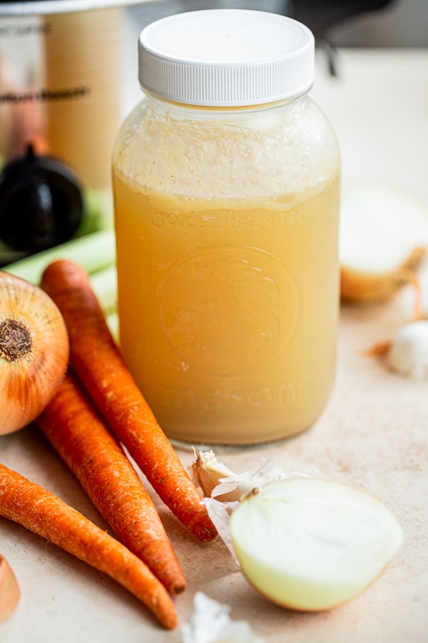 venison stock in a quart jar with onions, carrots and celery