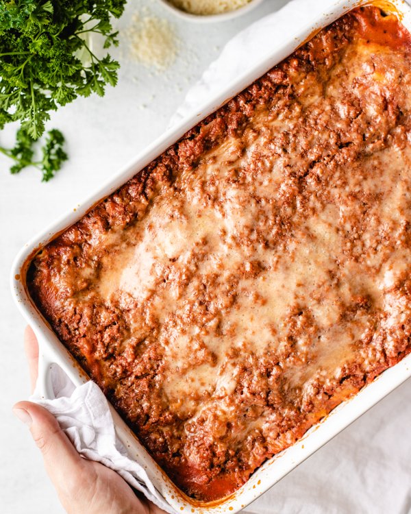 venison lasagna baked in a white casserole dish