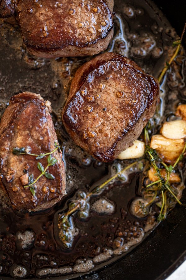 venison soaked in buttermilk in a cast iron pan