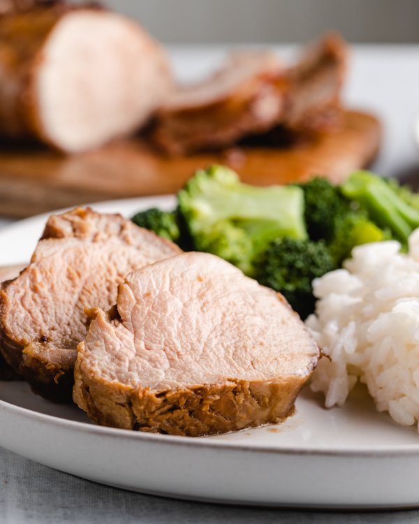 honey garlic pork tenderloin with ginger and garlic on a plate with rice and broccoli