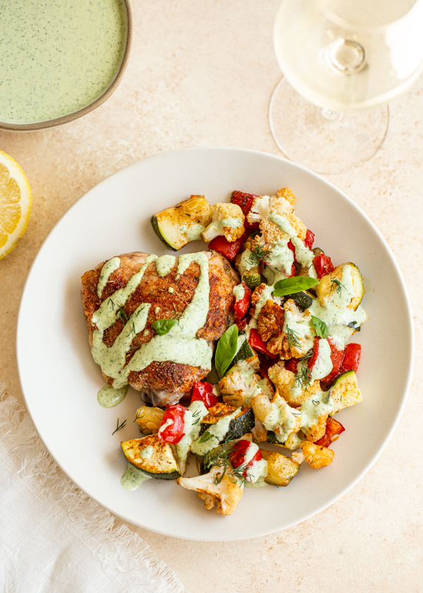 a plate of chicken and vegetables with creamy garlic and herb sauce