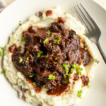 smoked venison shanks over a bed of mashed potatoes