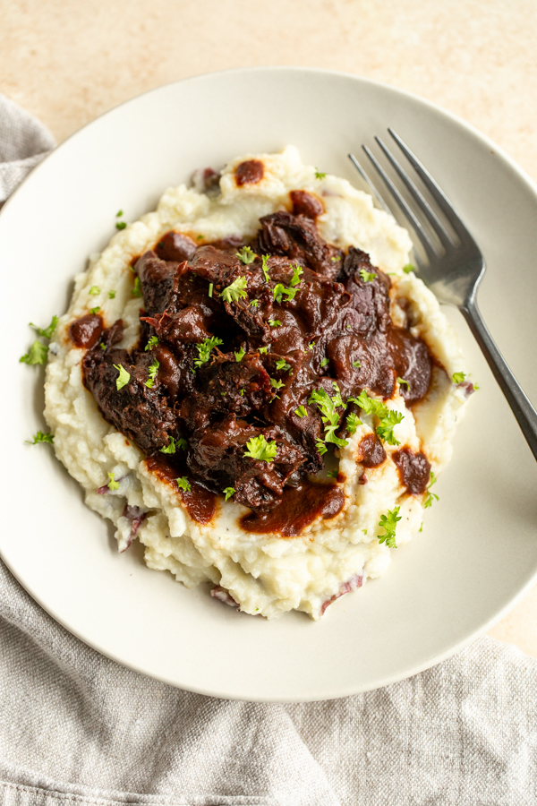 smoked venison shanks over a bed of mashed potatoes