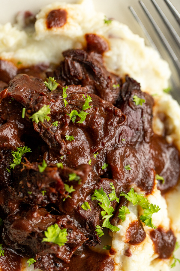 smoked venison shanks over a bed of mashed potatoes