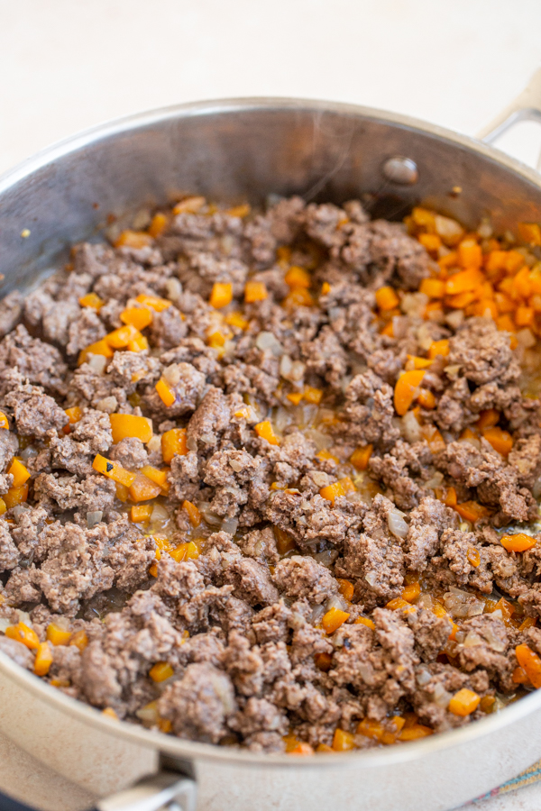 ground venison with carrots and onions in a pan