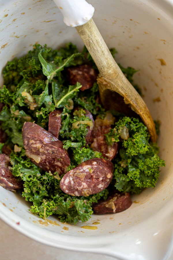 kale and sausage in a while bowl