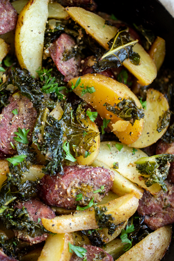 potatoes, sausage, kale and onion in a cast iron skillet