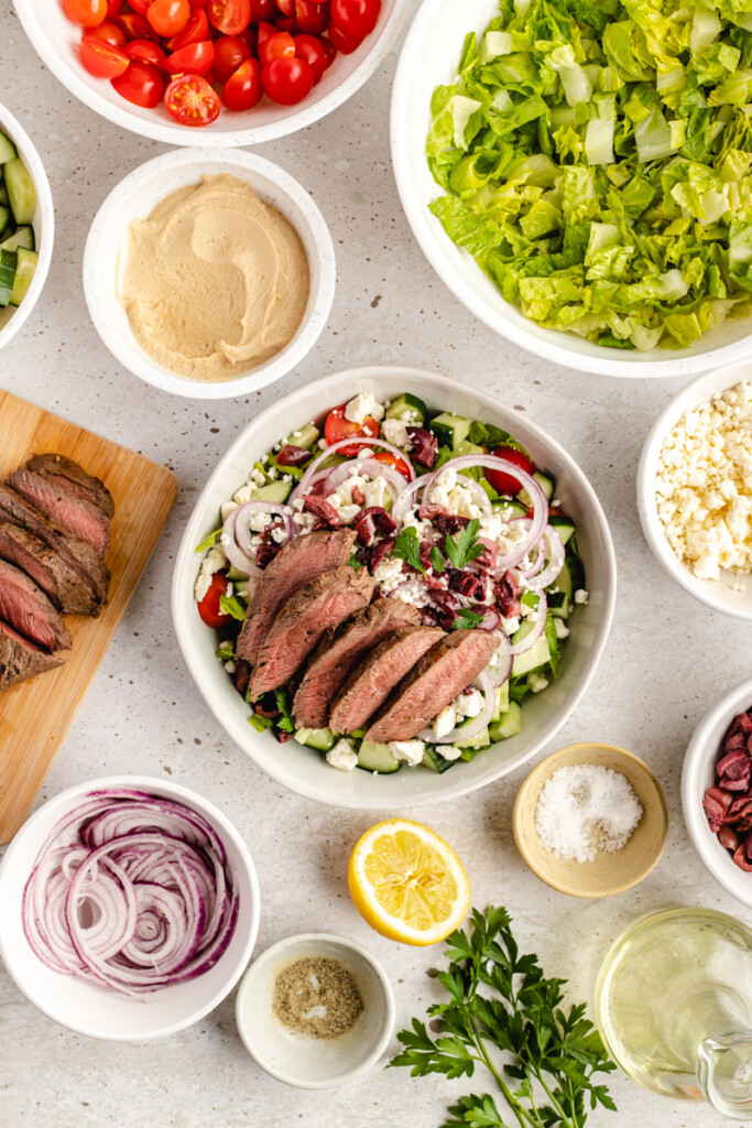 Mediterranean Venison Steak Bowl with ingredients surrounding white bowl