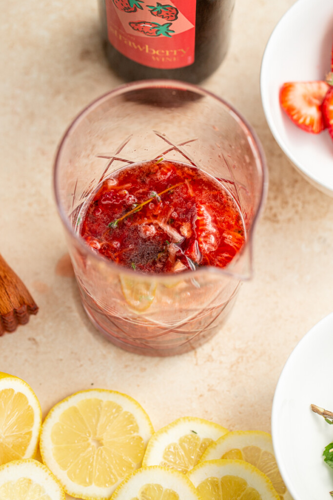 strawberries and herbs muddled in a cocktail pitcher