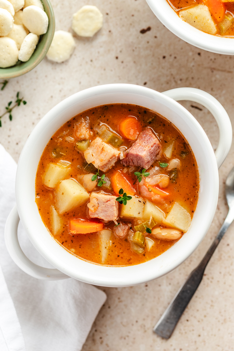 Ham and Bean Soup in white bowl garnished with fresh thyme