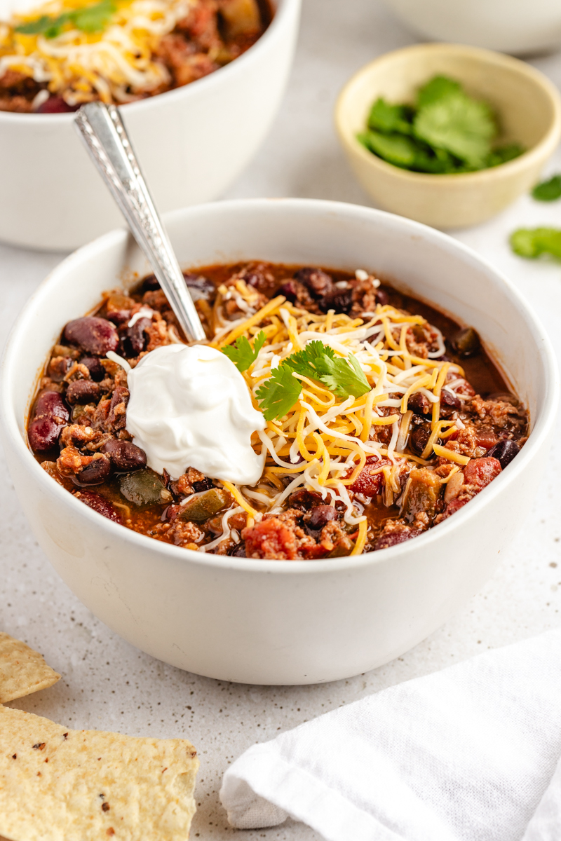 Chili in white bowl with toppings