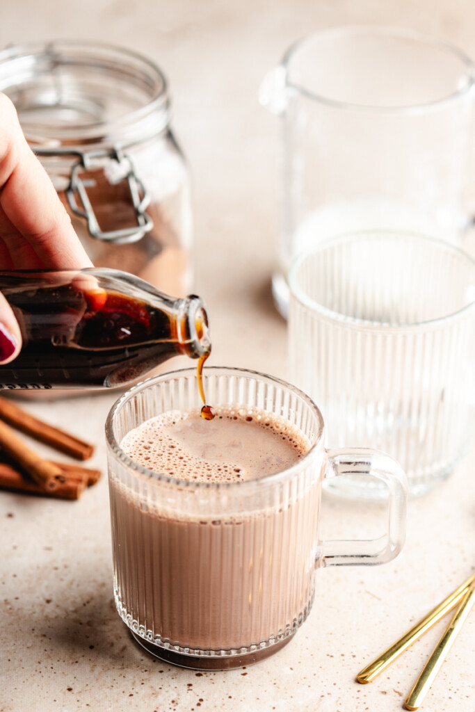 vanilla extract being splashed into hot cocoa