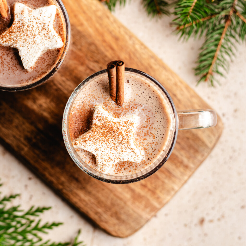 hot chocolate with star shaped cool whip and cinnamon sprinkled on top