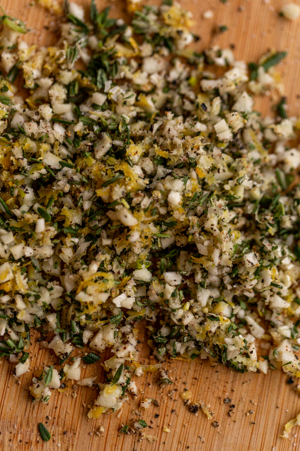 herbs, garlic and lemon chopped on a cutting board