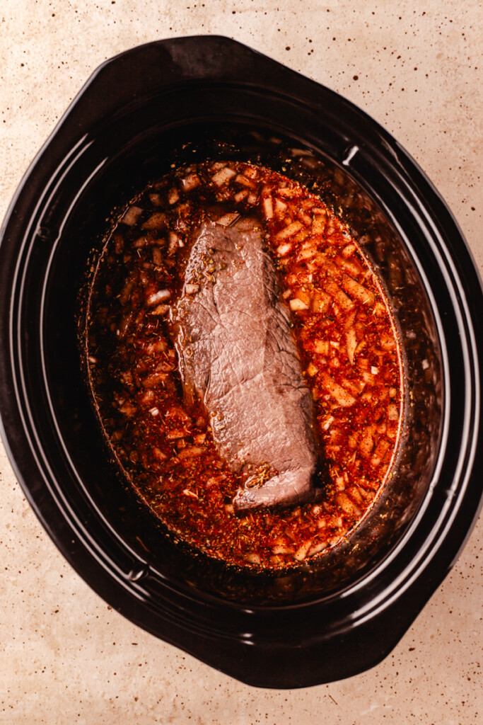 Venison roast in crock pot with birria taco ingredients