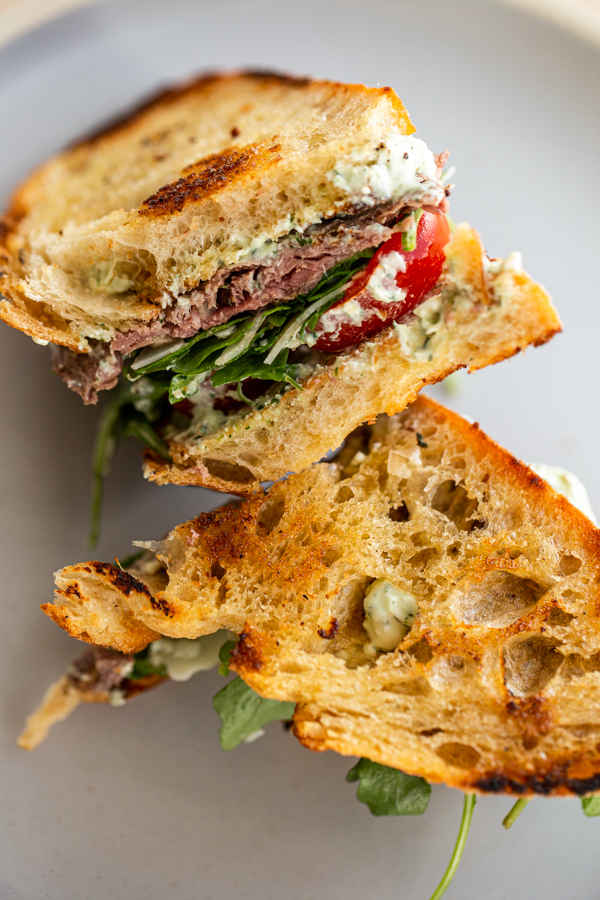 Venison steak sandwich on a blue plate