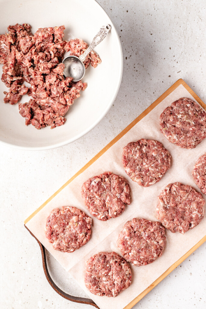 Raw Venison Breakfast Sausage Patties on parchment paper and cutting board