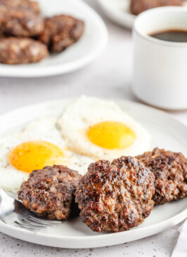 Venison Breakfast Sausage patties on white plate with eggs