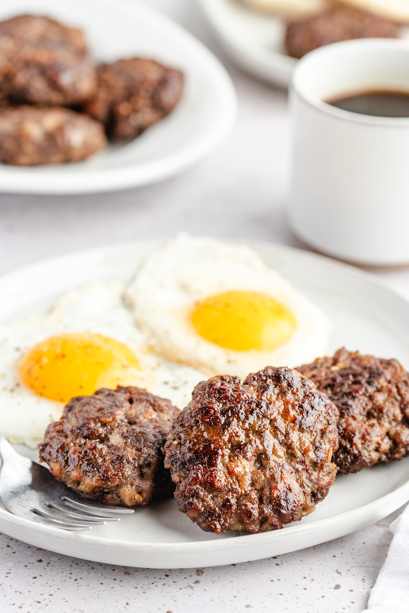 Venison Breakfast Sausage patties on white plate with eggs