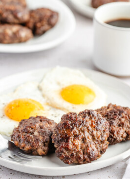 Venison Breakfast Sausage patties on white plate with eggs