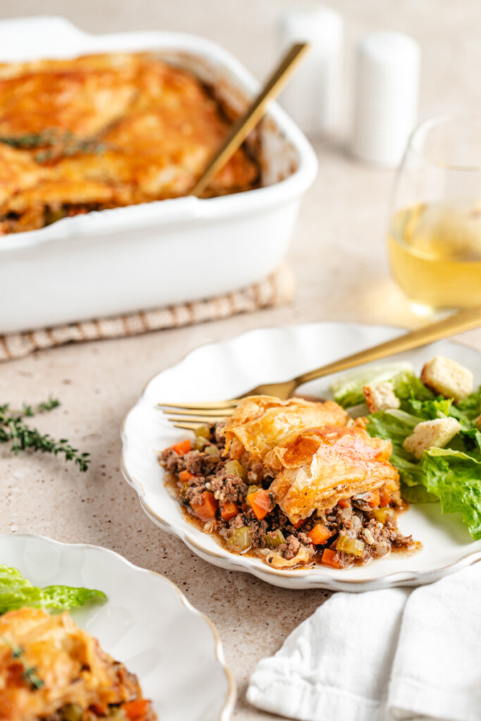 Venison Pot Pie on a white plate with a green salad