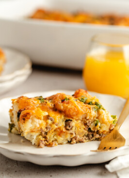 A slice of Venison Breakfast Casserole on a white plate with a fork