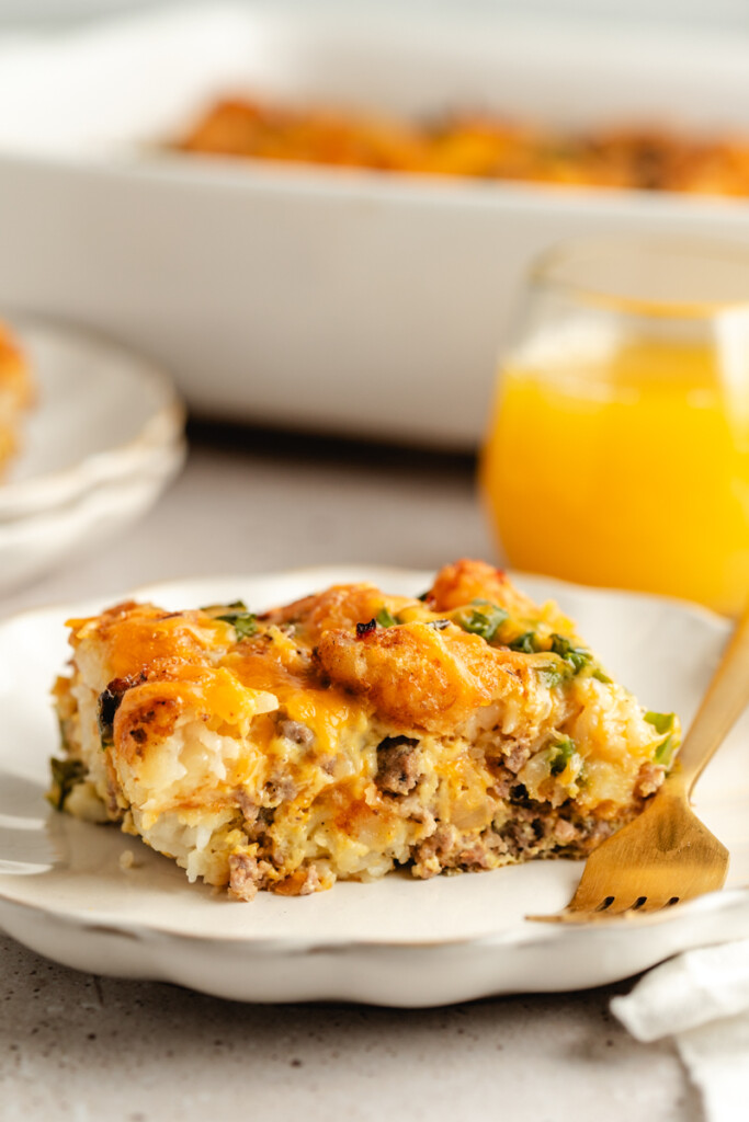 A slice of Venison Breakfast Casserole on a white plate with a fork