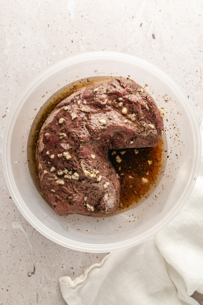A steak with marinate in a bowl