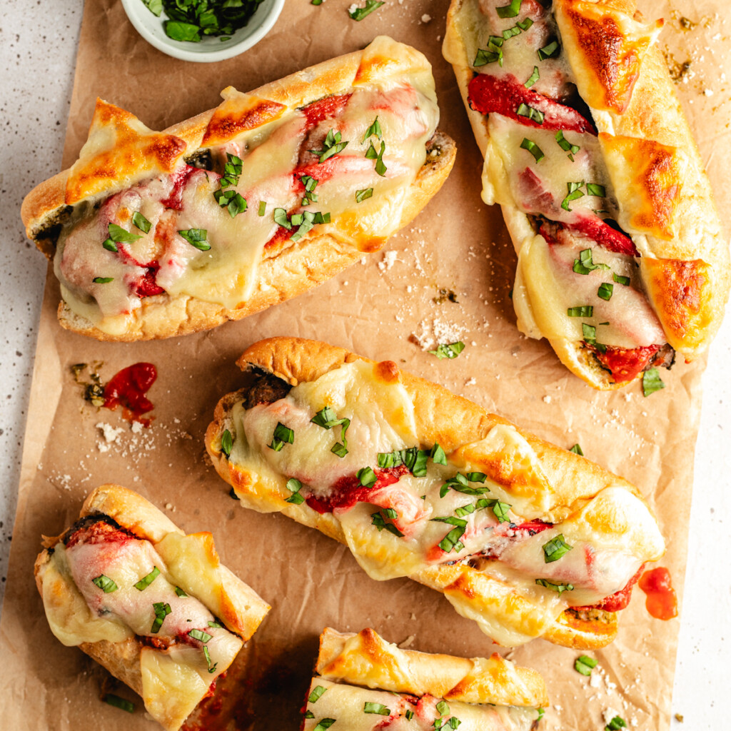 Messy venison meatball subs on parchment paper