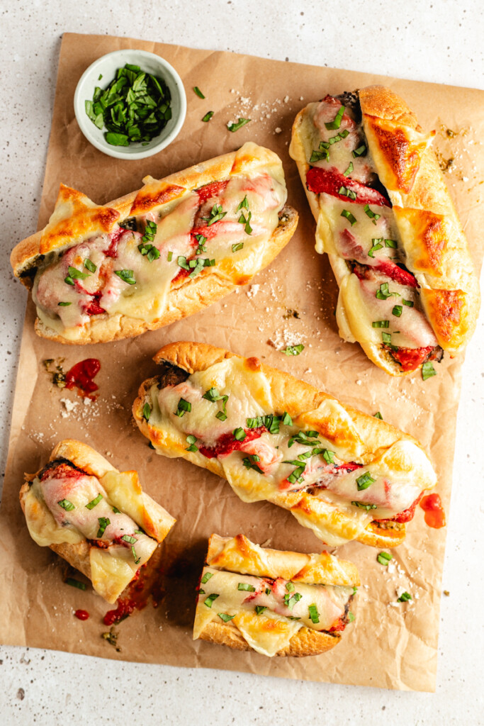 Venison meatball subs scattered and messy on a parchment paper