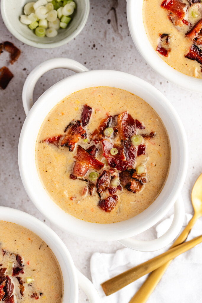 A white bowl filled with Chicken Corn Chowder and topped with bacon and green onions