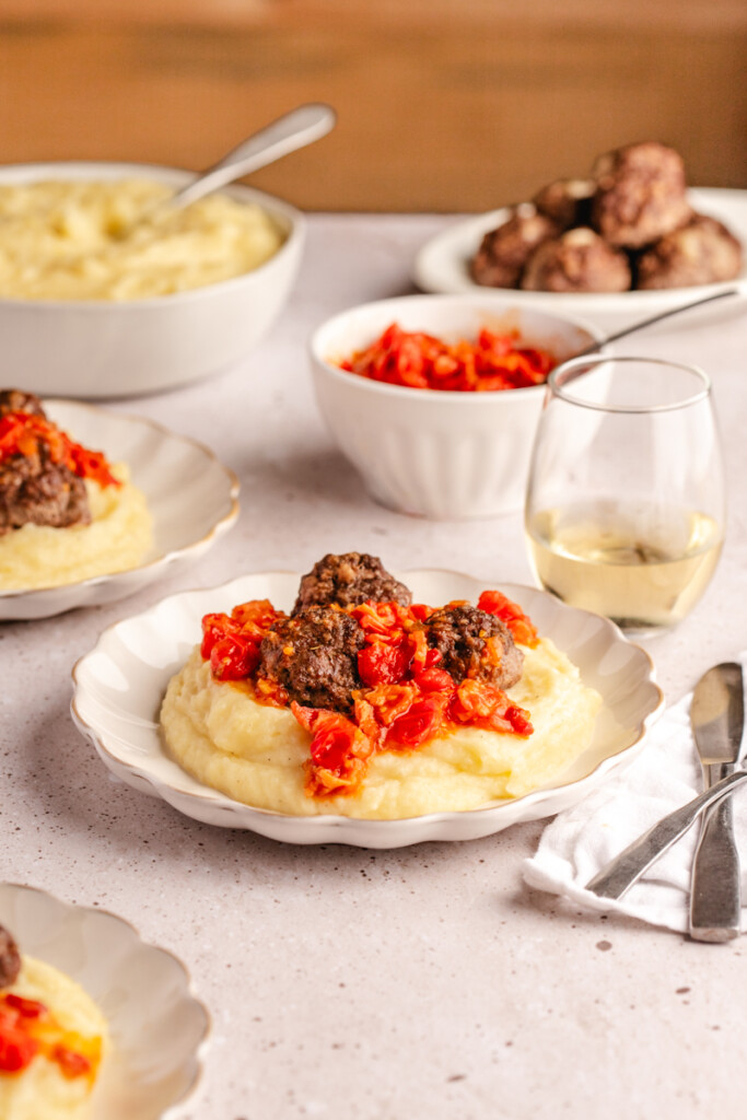 A table setting with stuffed meatballs, mashed potatoes and tomato bacon jam