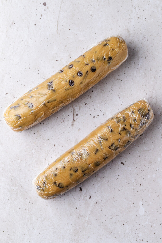 Two rolls of Brown Butter Slice & Bake Chocolate Chip Cookie dough wrapped in plastic wrap