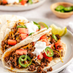 Ground venison tortilla tacos on a white plate
