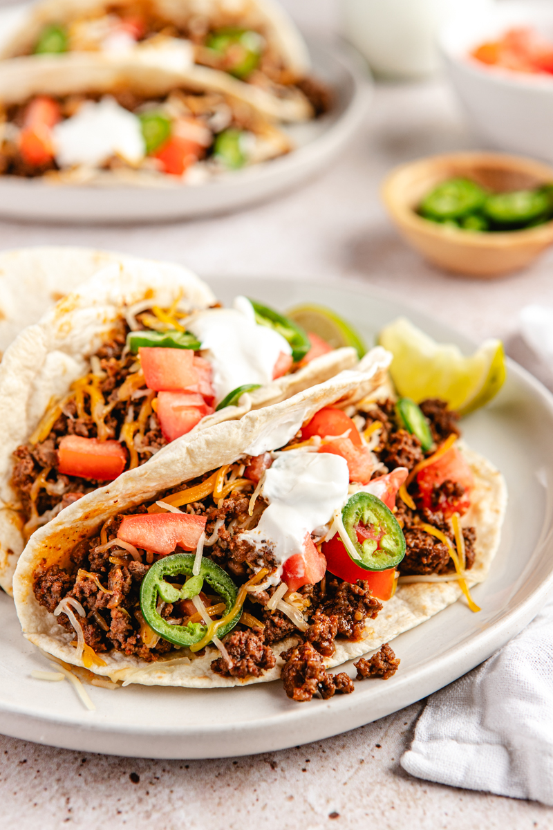 Ground venison tortilla tacos on a white plate