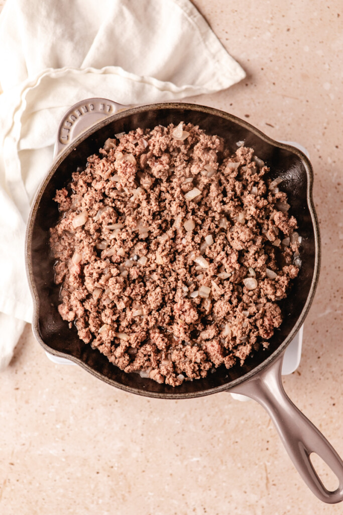 Ground venison and onions sautéing in cast iron pan