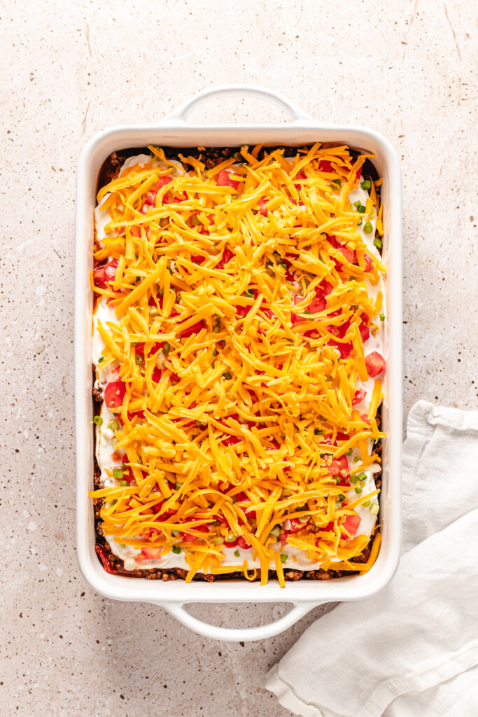high protein taco casserole topped with shredded cheddar cheese.