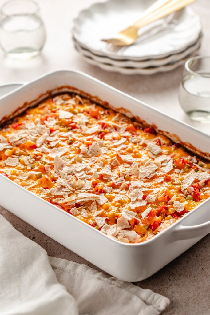 high protein taco casserole topped with shredded cheddar cheese and crushed tortilla chips.