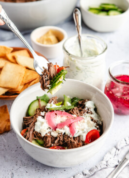 A fork taking a bite out of a Greek Venison Power Bowl